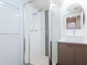 a bathroom with a shower and a sink at The Commodore, 14, 9-11 Donald Street- Unit in the heart of town with views & free wi-fi in Nelson Bay