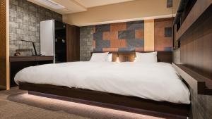 - une chambre avec un grand lit blanc dans l'établissement Galois Hotel Shinokubo, à Tokyo