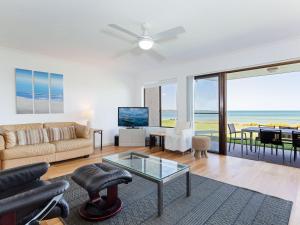 a living room with a couch and a table at The Pelicans 2 ground floor unit on the waterfront in Soldiers Point