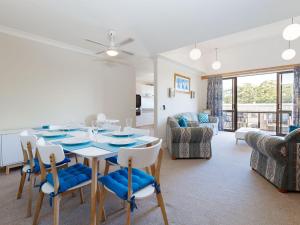 a dining room and living room with a table and chairs at The Poplars, 6,36 Magnus Street - Unit with fabulous views and a complex pool in Nelson Bay