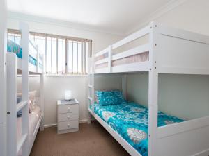 a bedroom with two bunk beds and a bed at Walk on Birubi 1 Pet Friendly WI-FI Boat Parking and Water Views in Anna Bay