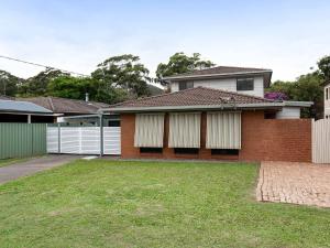 a brick house with a fence and a yard at Willows At The Bay Large House with Aircon WI-FI and Boat Parking in Shoal Bay