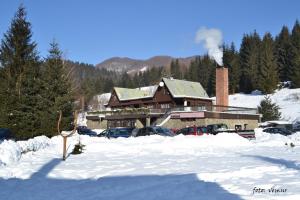 a ski lodge with cars parked in the snow at Chata Žiar in Rajecká Lesná