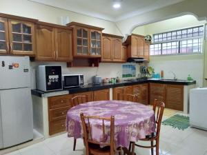 een keuken met een tafel met een paarse tafelkleed erop bij Kayu Merbau Homestay in Seri Iskandar