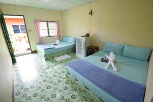 um quarto com uma cama com um brinquedo branco em Mukda Guesthouse em Trat