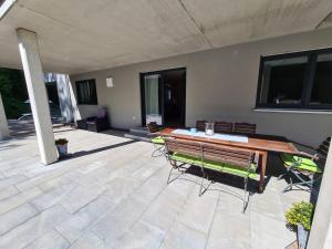 a patio with a wooden table and chairs on it at Ferienwohnung CaLuMa in Wangen im Allgäu