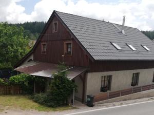 a house with a gambrel roof with windows at Chata Roudny in Černý Dŭl