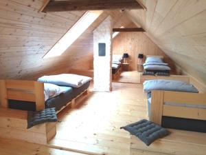 a room with several beds in a wooden cabin at Apartmány Statek u Dobráka in Třeboň