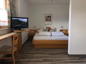 ein Hotelzimmer mit einem Bett und einem Flachbild-TV in der Unterkunft Appartements Daisy in Serfaus
