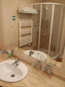 a bathroom with a sink and a mirror and a tub at Sunshine 208 apartman in Balatonszárszó