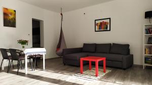 a living room with a couch and a red stool at Sirály apartman in Keszthely