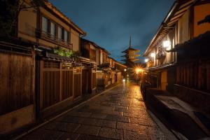 an alley with buildings and a pagoda at night at Campton Kiyomizu Vacation Rental in Kyoto