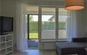 een woonkamer met een groot raam en een televisie bij 2 Bedroom Nice Home In Ystad in Ystad