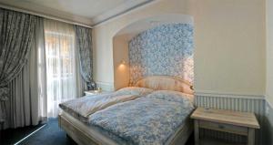een slaapkamer met een groot bed met een blauwe muur bij Appartement Erwin & Eleonore Hüttl - Top 1 in Neukirchen am Großvenediger