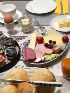 una mesa con un plato de comida con queso y pan en HausTanneneck, en Duhnen