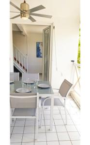 a dining room with a white table and chairs at Appartement REVE ENSABLE, classé 3 étoiles, vue mer et montagne, mail de Rodrigues, Ermitage-Les-Bains, 6 personnes in Filaos