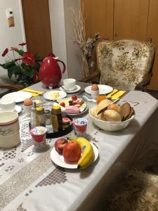 una mesa con platos de comida y fruta. en HausTanneneck, en Duhnen