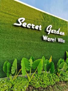 una señal para una empresa de jardinería con plantas delante en Secret Garden Warni Villa (MUAR), en Muar