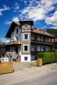 una grande casa bianca con tetto marrone di Das Nordberg Guesthouse a Garmisch-Partenkirchen