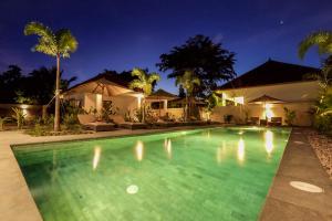 a swimming pool in front of a house at night at Green Valley Lombok in Selong Belanak