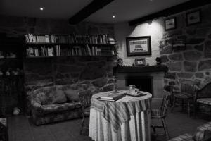 Una sala de estar con una mesa y una chimenea. en O cuco de Mondariz, en Mondariz