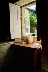 eine Vase auf einem Tisch vor einem Fenster in der Unterkunft O cuco de Mondariz in Mondariz