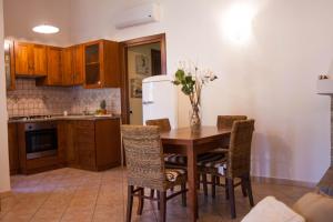 a kitchen with a table with chairs and a refrigerator at Villa Sweet Simius in Villasimius
