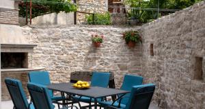 a patio with a table and chairs and a brick wall at Moderno 3 Casa Vecchia in Peroj