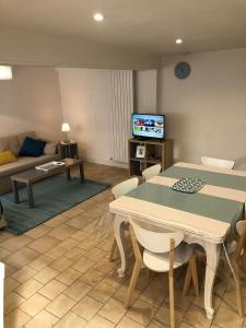 una sala de estar con una mesa y un sofá en L'HISTORIQUE - Maison rénovée dans le centre-ville de Bayeux, en Bayeux