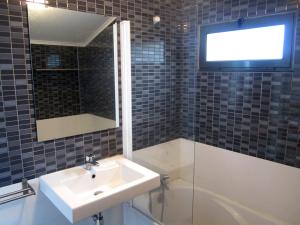 een badkamer met een wastafel en een tv aan de muur bij Casa Das Furnas in Furnas +29 foto's