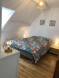 um quarto com uma cama com um cobertor colorido em L'HISTORIQUE - Maison rénovée dans le centre-ville de Bayeux em Bayeux