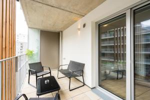 Un balcón con sillas y mesas en un edificio en FeelGood Apartments GreenLiving | contactless check-in, en Viena