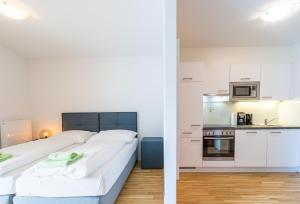 1 dormitorio y sala de estar con 1 cama y cocina en FeelGood Apartments GreenLiving | contactless check-in, en Viena