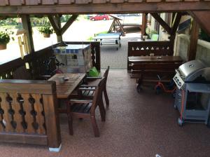 a patio with wooden tables and chairs and a grill at Apartmany Samuel in Rokytnice nad Jizerou