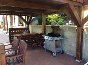 un patio con parrilla, mesa y banco en Apartmany Samuel en Rokytnice nad Jizerou