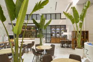 een restaurant met tafels, stoelen en planten bij Hotel Z in Taichung