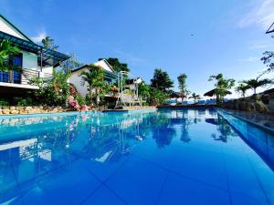 a swimming pool with blue water in front of a building at Palafita Bungalow in Phong Nha +59 photos
