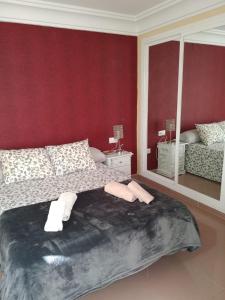 ネルハにあるNERJA APARTAMENTO TURISTICO 2Bの赤い壁のベッドルーム1室(ベッド1台付)