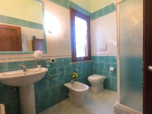 a bathroom with a sink and a toilet and a mirror at Villa Sweet Simius in Villasimius +44 photos