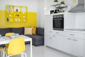 a kitchen with a couch and a table and yellow chairs at Mer Epanomi in Órmos