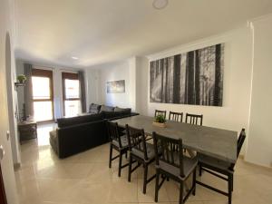 a living room with a table and chairs and a couch at SWEET HOME AYAMONTE in Ayamonte