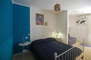 カステッランマーレ・デル・ゴルフォにあるAppartamento Bouganvilleの青い壁のベッドルーム1室(ベッド1台付)