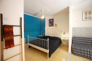 カステッランマーレ・デル・ゴルフォにあるAppartamento Bouganvilleの青い壁のベッドルーム1室