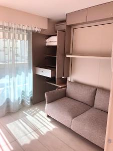 a living room with a couch and a window at Studios Nice Gambetta in Nice