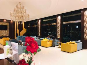 a living room with yellow and blue couches and a man bending over at Randan in Riyadh