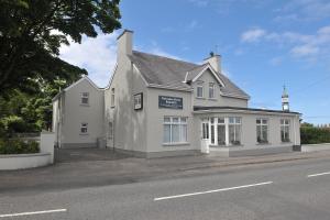 een wit gebouw aan de straatkant bij Portcaman House in Bushmills