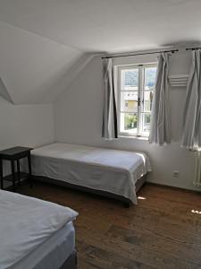 a bedroom with two beds and a window at Villa Bertholini in Bad Ischl