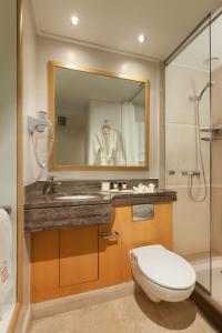 a bathroom with a toilet and a sink and a mirror at Central Hotel in Athens