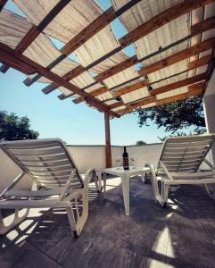 two chairs and a table with a bottle of wine at Apartmani Mersol Nin in Nin