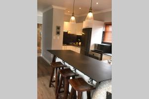 a kitchen with a large black table and wooden chairs at Winner in the Winelands in Franschhoek +9 photos